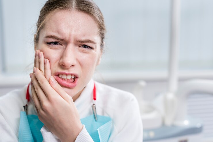Woman holding her cheek in pain due to a severe tooth infection